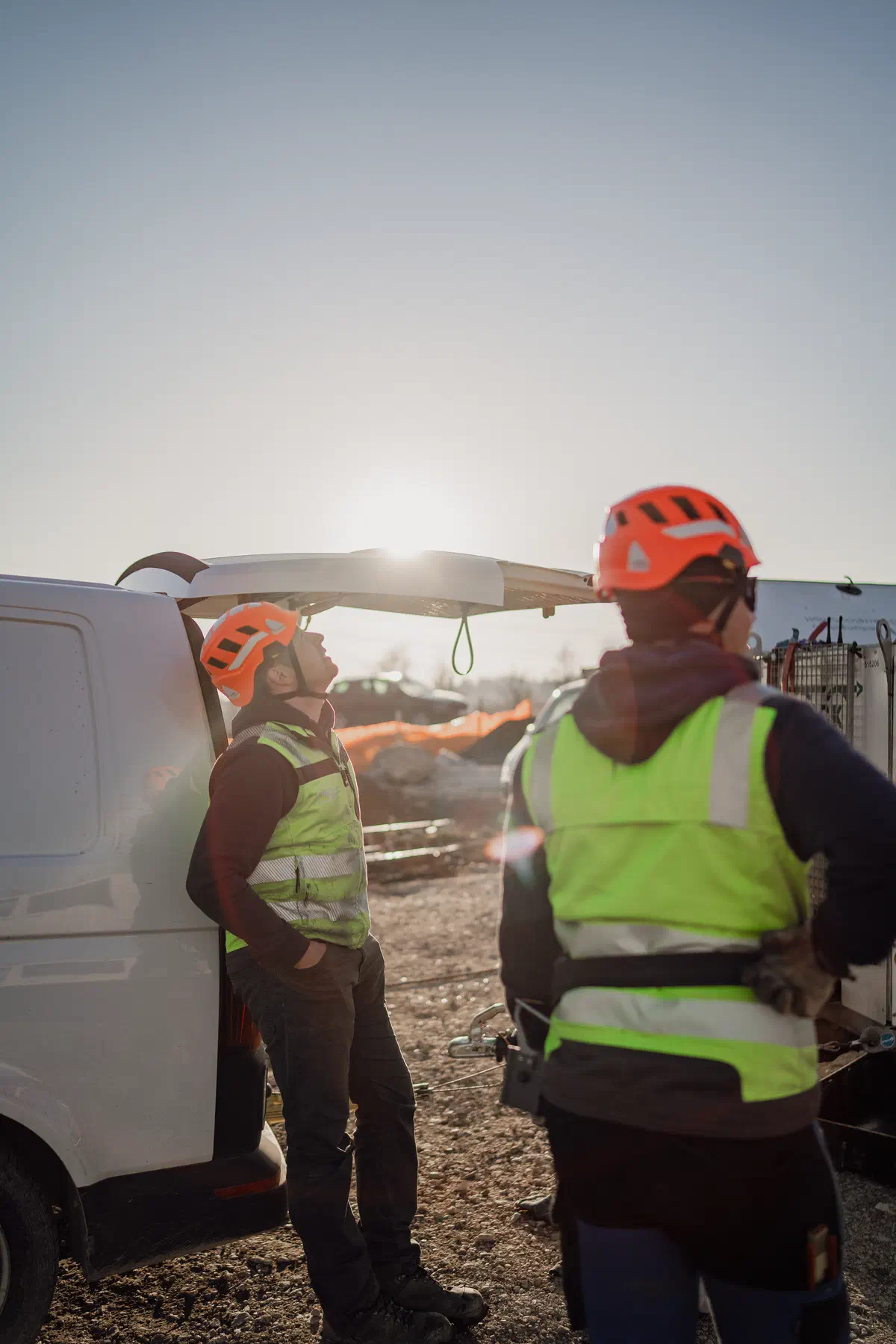 Bauarbeiter in Arbeitskleidung am Servicefahrzeug auf einer Baustelle.