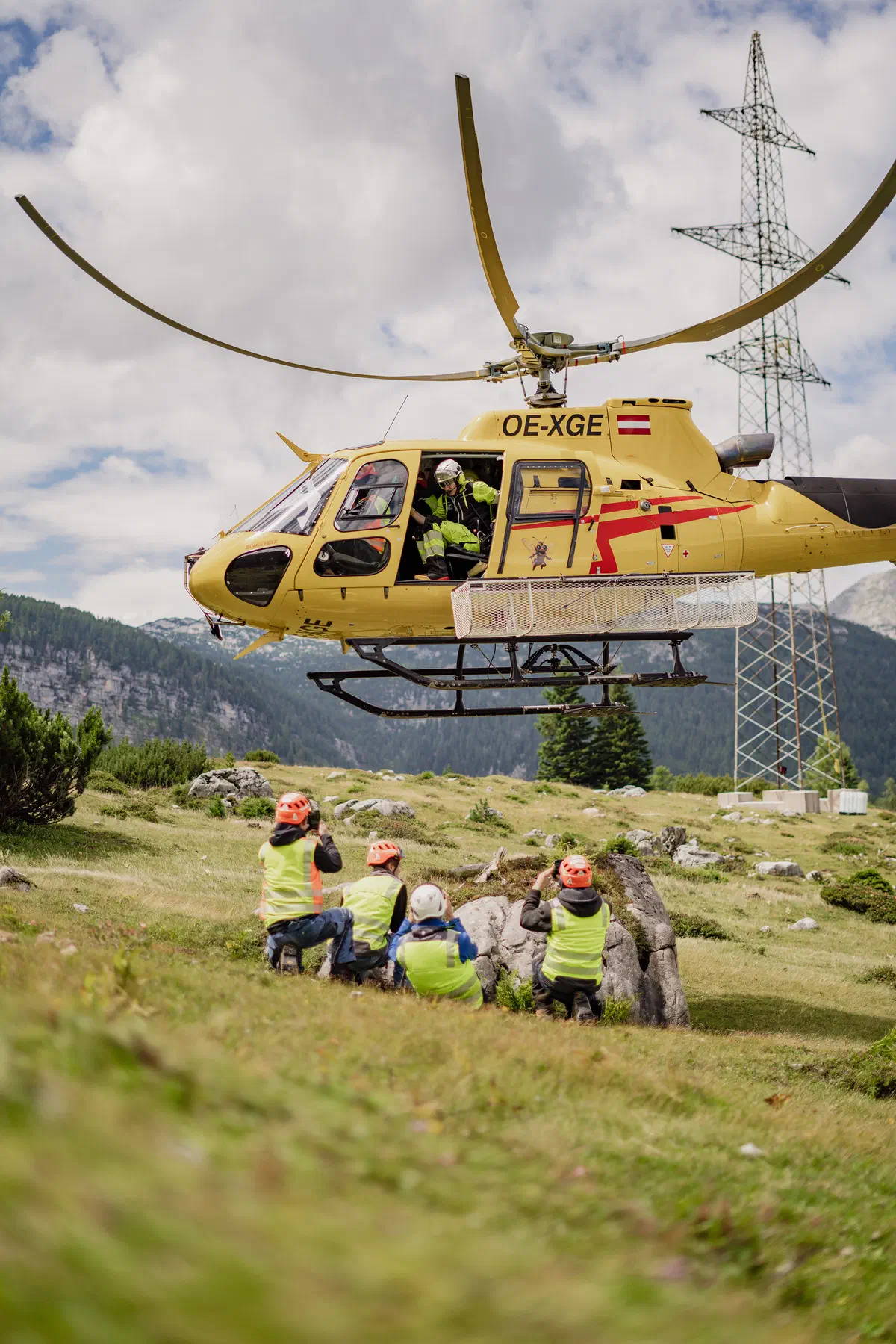 Helikopter bei der Strommast-Montage im alpinen Gelände.